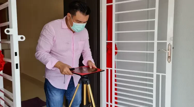 On-site Home Feng Shui Survey: Feng Shui Master Malaysia, Master Edward Chin standing solemnly at the center of the front door of the residence, observing the compass movements in PJ, Selangor, Malaysia