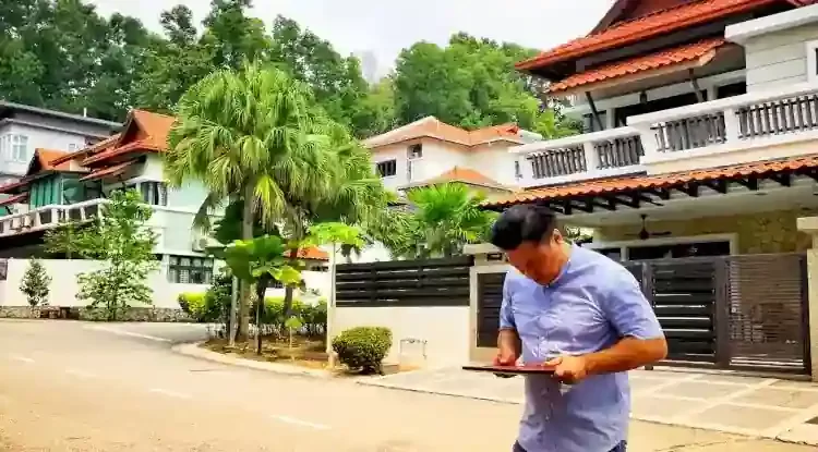 Photo of Feng Shui Master Malaysia, Master Edward Chin holds a compass while surveying the Feng Shui of a semi-detached house on site in Cheras, Kuala Lumpur (KL), Malaysia
